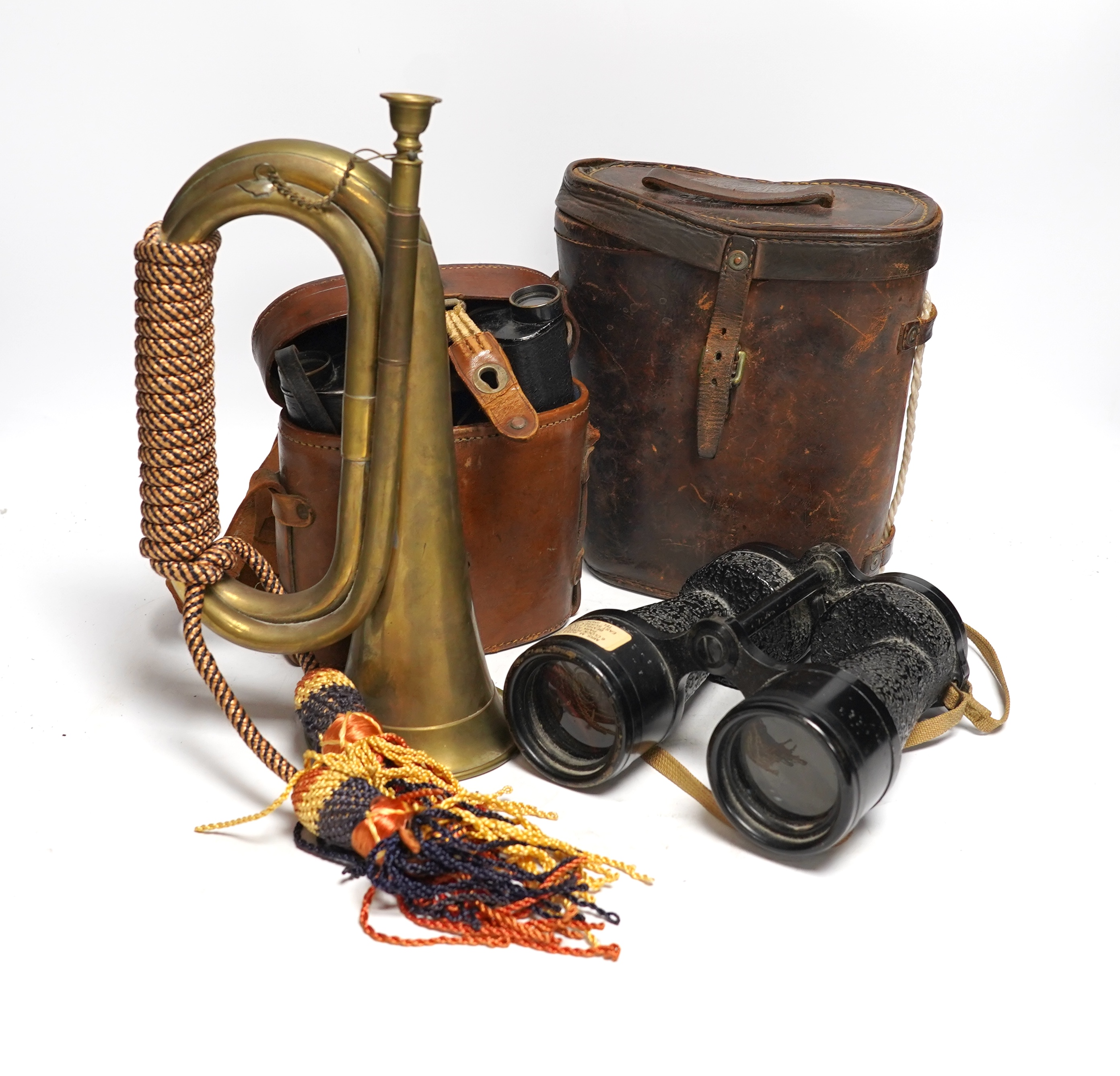 Two cased pairs of binoculars and a brass bugle.